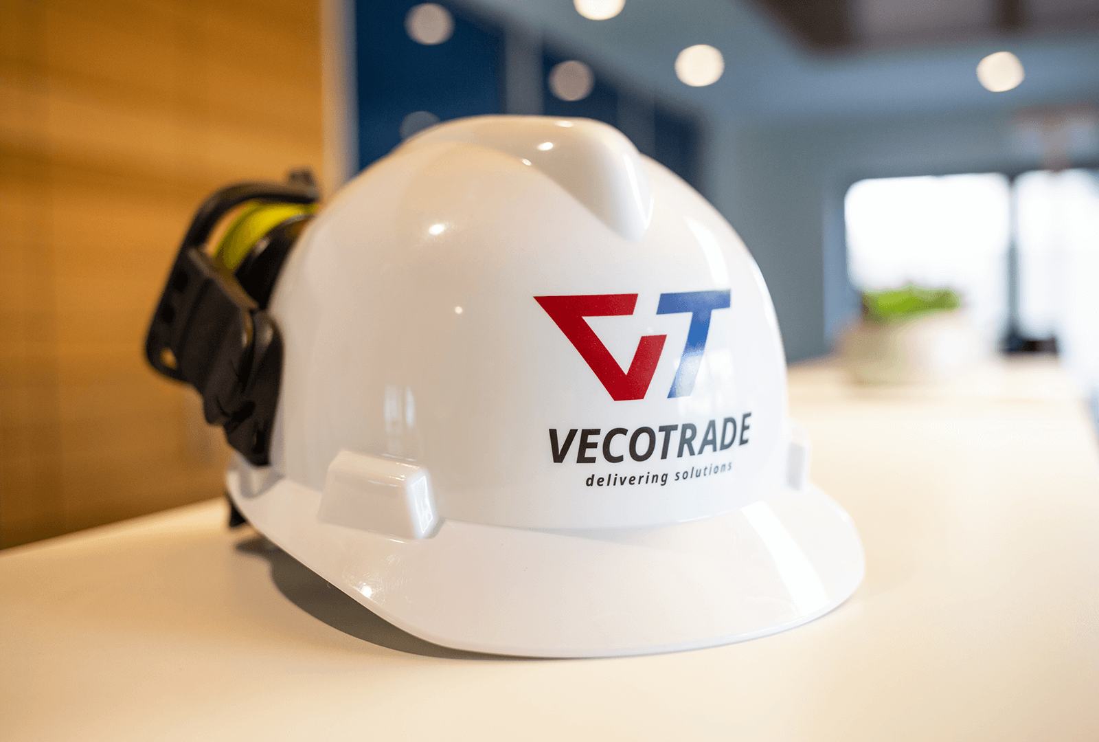 White safety helmet with the Vecotrade logo on a meeting table